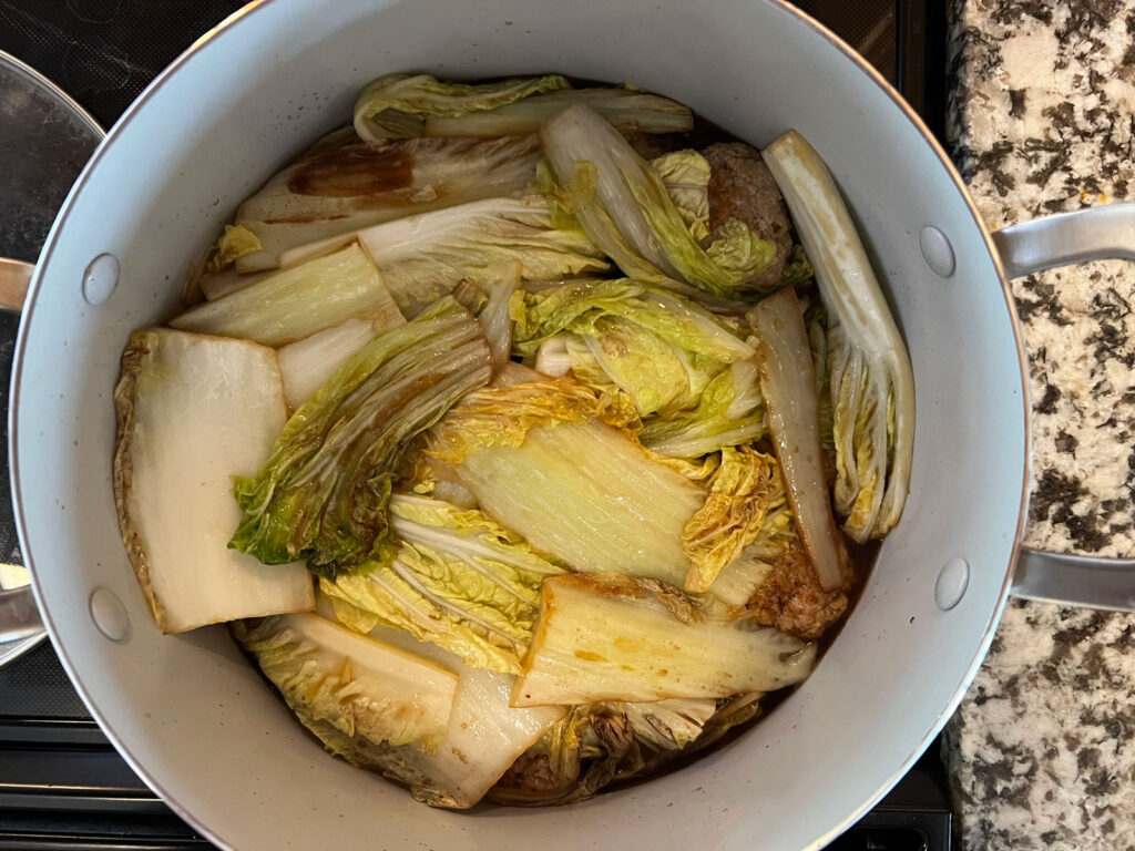 Place all of your browned meatballs gently on top of the raw cabbage bed in Pan 2. 